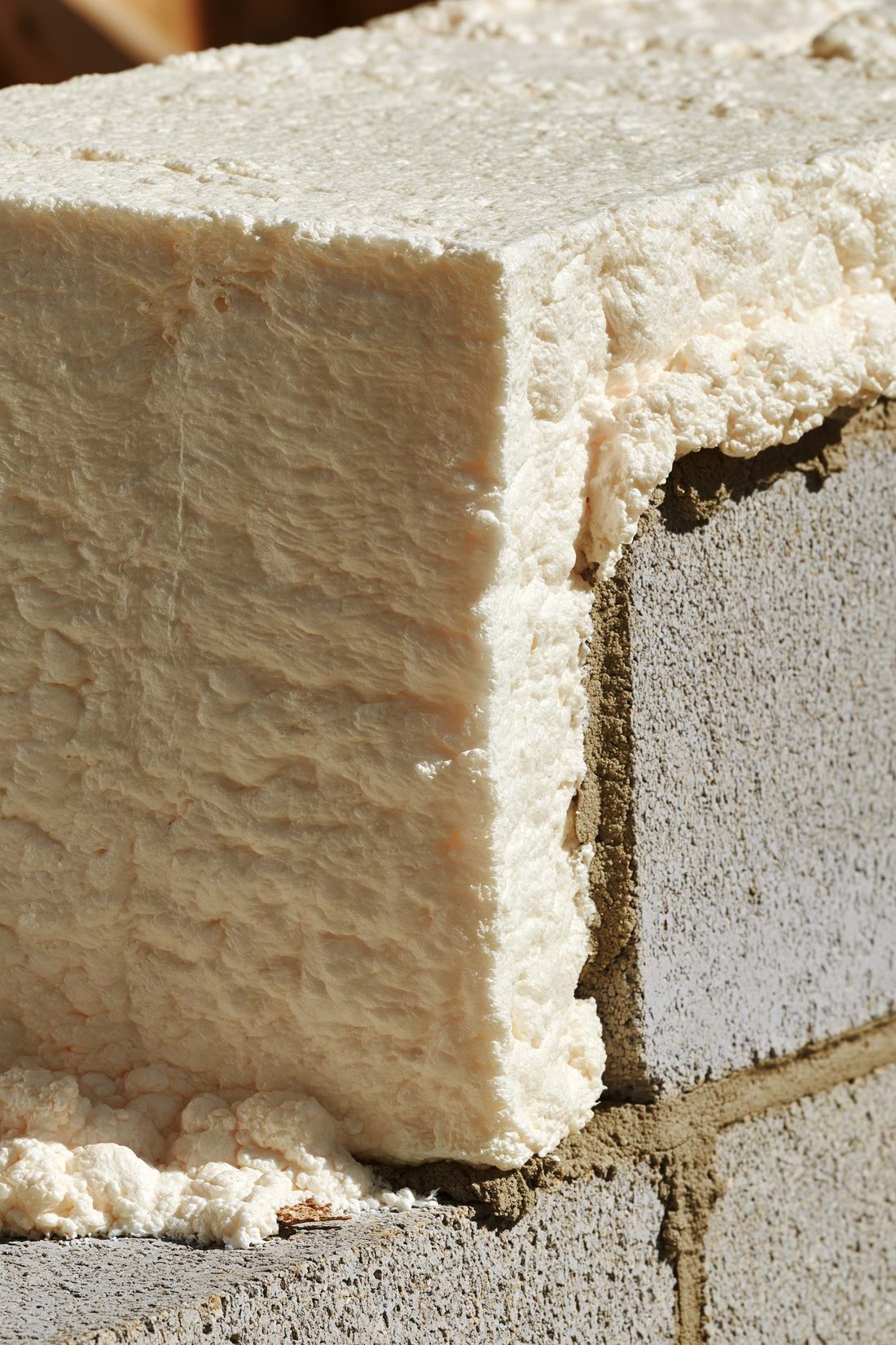 Rigid closed-cell foam with a cleanly trimmed edge against a concrete block wall